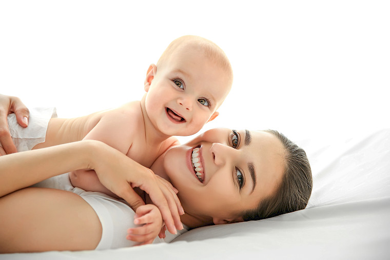 Una mamma felice tiene in braccio il suo bambino sorridente