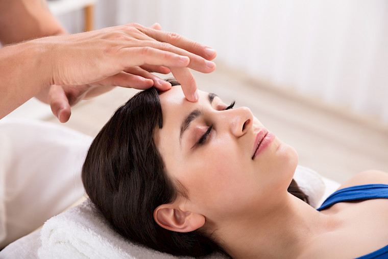 A woman relaxes during a Reiki treatment