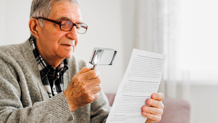 Old man with macular degnerationt trying to read