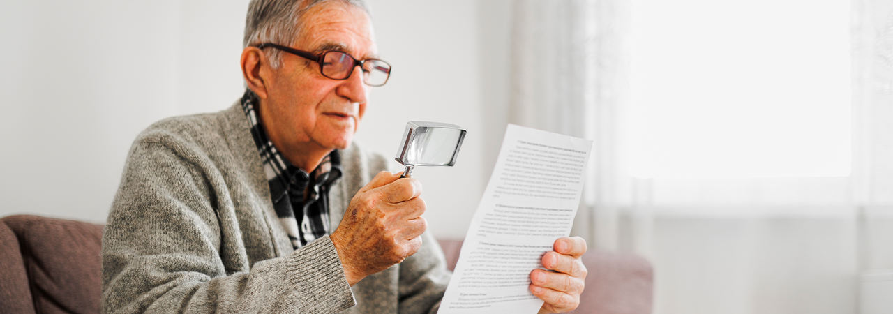 Old man with macular degnerationt trying to read